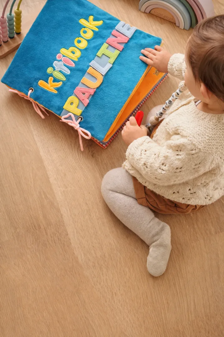 Enfant jouant avec son Kitibook — livre d'éveil personnalisé Kitimimi